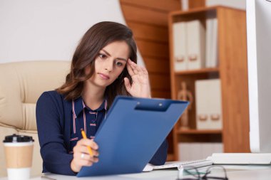 Pensive genç iş kadını yıllık mali rapor okuma