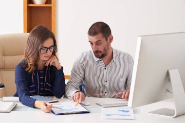 Ofisteki toplantıda grafikleri ve diyagramları tartışan ciddi iş adamları