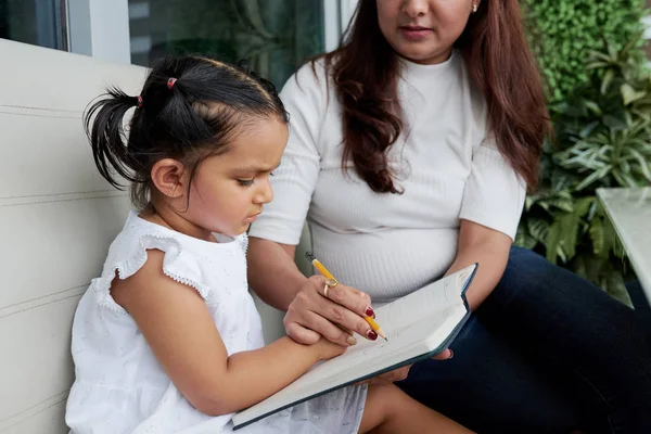 Joven Maestra Sentada Con Niña Sofá Enseñándole Cómo Escribir Con —  Fotos de Stock