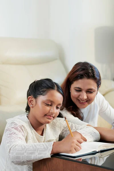 Niña Sentada Mesa Tomando Notas Cuaderno Con Madre Sentada Cerca —  Fotos de Stock