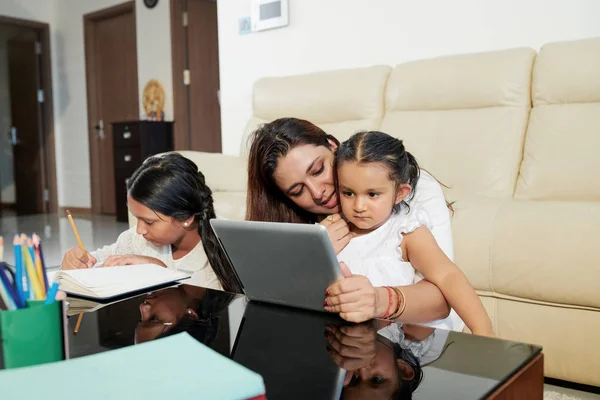 Mother Sitting Table Her Little Daughter Showing Her Something Tablet — Stock Photo, Image