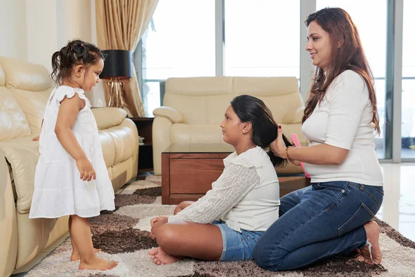 Felice Madre Pettinando Figlia Maggiore Facendole Acconciatura Mentre Bambina Piedi — Foto Stock