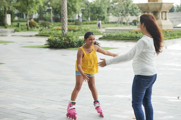 年轻的女孩溜冰轮滑与她的母亲在公园 — 图库照片