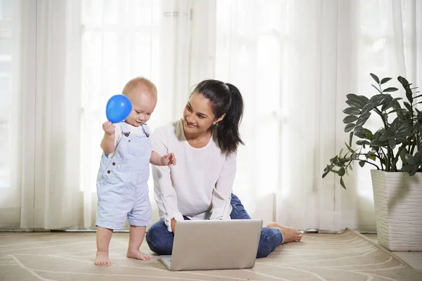 Junge Frau Arbeitet Hause Laptop Als Ihr Sohn Mit Luftballon — Stockfoto