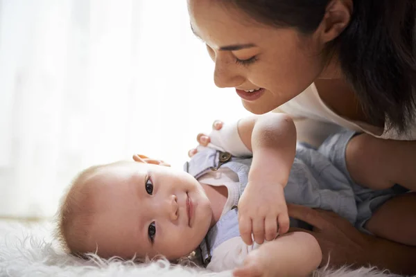 Sonriente Joven Madre Mirando Pequeño Hijo Lindo Acostado Alfombra Piel — Foto de Stock