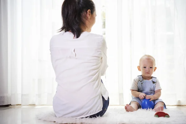 Mãe Sentada Chão Desligando Para Janela Mas Seu Bebê Brincando — Fotografia de Stock