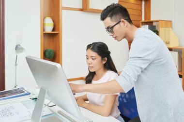 Bilgisayardaki ekranda bilgi tartışan programcılar ekibi