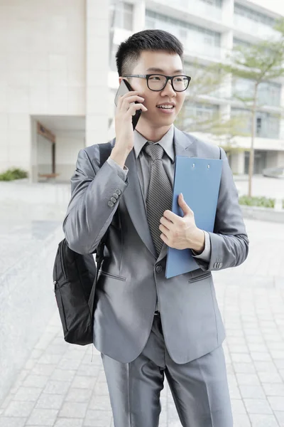 Aziatische Jonge Kantoormedewerker Holding Klembord Heeft Een Gesprek Mobiele Telefoon — Stockfoto