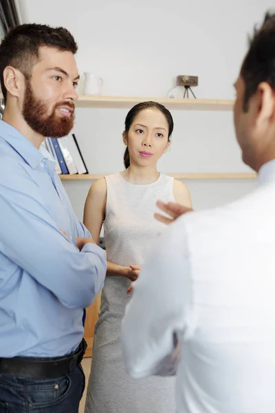 Bebaarde Jonge Zakenman Staat Samen Met Aziatische Zakenvrouw Luisteren Naar — Stockfoto