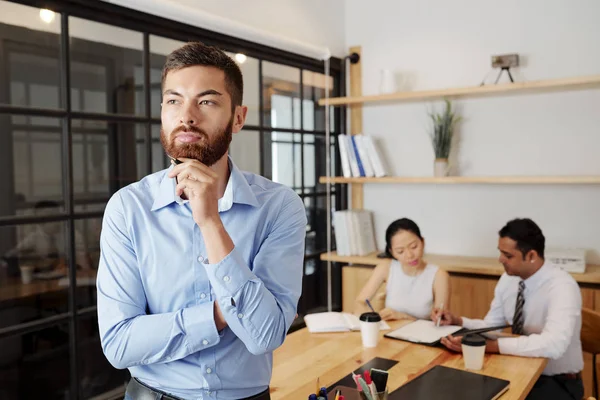 Jonge Bebaarde Zakenman Staande Kantoor Denken Iets Met Zijn Partners — Stockfoto