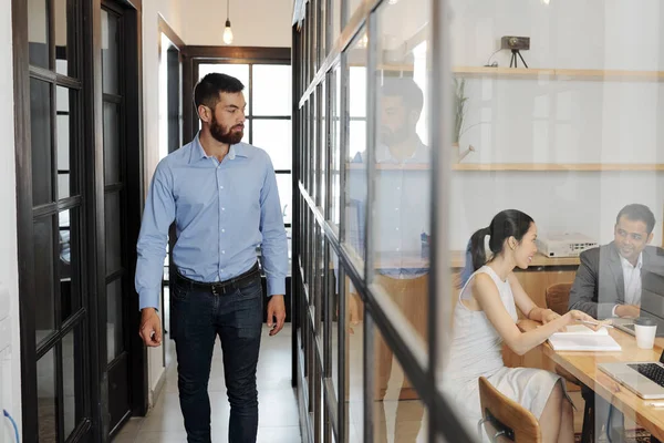 Junger Bärtiger Geschäftsmann Der Den Büroflur Entlangläuft Und Seine Kollegen — Stockfoto