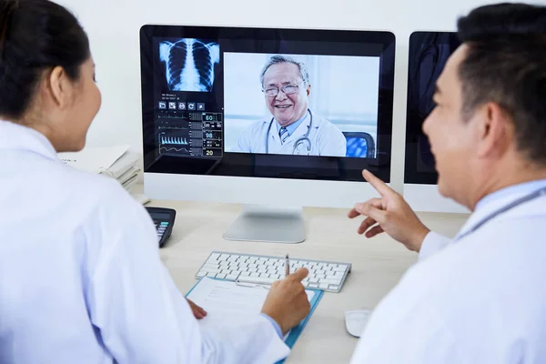 Visão Traseira Dois Médicos Asiáticos Sentados Frente Monitor Computador Discutindo — Fotografia de Stock