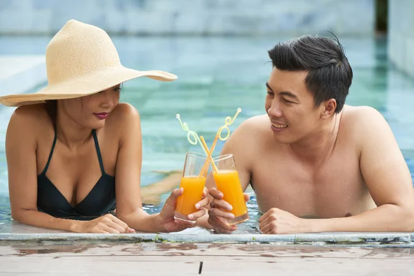 年轻的越南男人和女人坐在游泳池里 用鸡尾酒杯敬酒 — 图库照片
