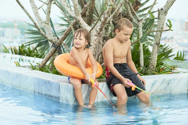 Two Friends Sitting Poolside Toy Rods Fishing Together Summer Holidays — Stock Photo, Image