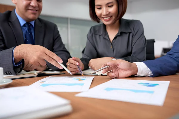 Gente Negocios Sentada Mesa Apuntando Documentos Con Gráficos Gráficos Discutiéndolo — Foto de Stock