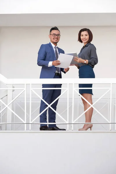 カメラに微笑むドキュメントとデジタルタブレットで階段に一緒に立っている2つのビジネスパートナーの肖像画 — ストック写真