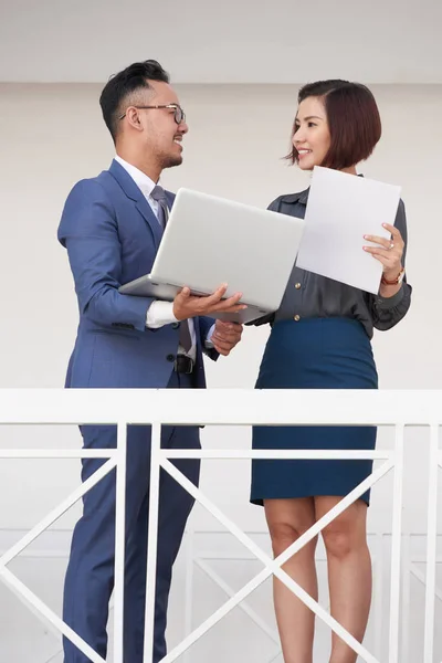 Due Colleghi Lavoro Sorridenti Possesso Contratto Lavoro Computer Portatile Discutendo — Foto Stock