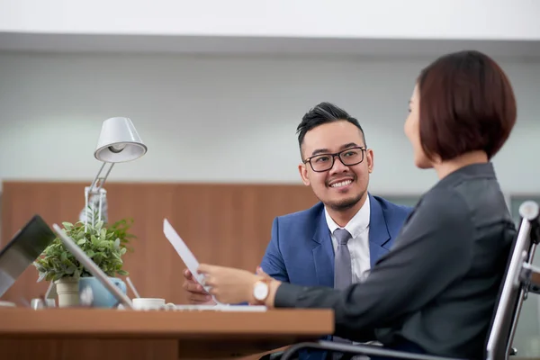 Gözlüklü Genç Asyalı Işadamı Kadınıyla Konuşuyor Ofiste Masada Otururken Gülümsüyor — Stok fotoğraf