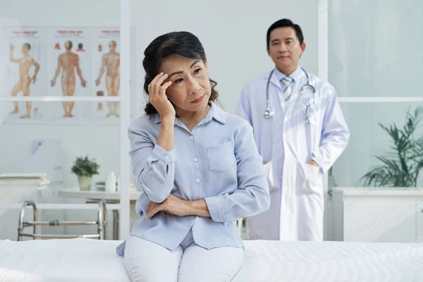 Triste Mulher Idosa Pensativo Sentado Cama Consultório Médico — Fotografia de Stock