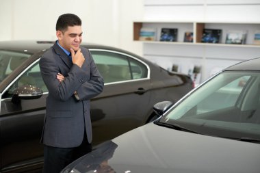 Showroom araba bakarak rüya karışık ırk adam gülümseyen