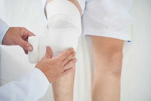 Imagen Recortada Del Médico Aplicando Vendaje Pierna Del Paciente — Foto de Stock