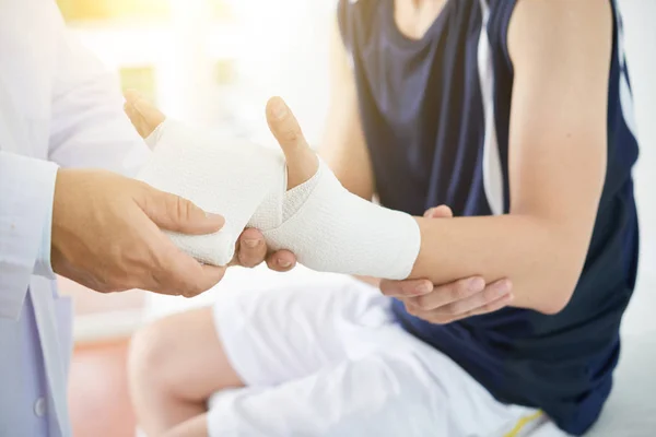 Médico Aplicando Vendaje Mano Rota Del Paciente Masculino — Foto de Stock