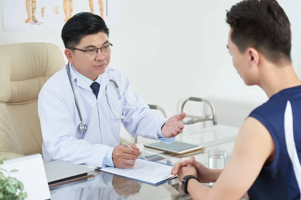 Médico Escuchando Las Quejas Paciente Joven Tomando Notas Historial Médico — Foto de Stock