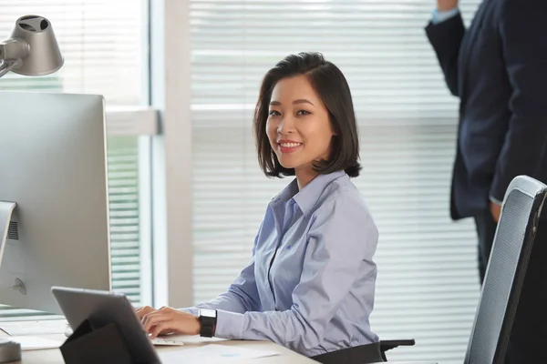 漂亮的年轻亚洲女企业家在她的办公室桌子上工作的计算机的肖像 — 图库照片
