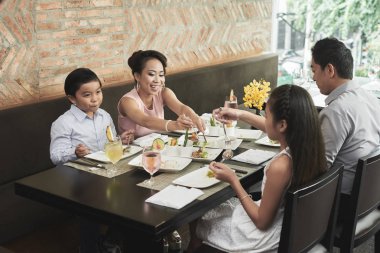 Asya Aile masada oturan ve restoran birlikte akşam yemeği var