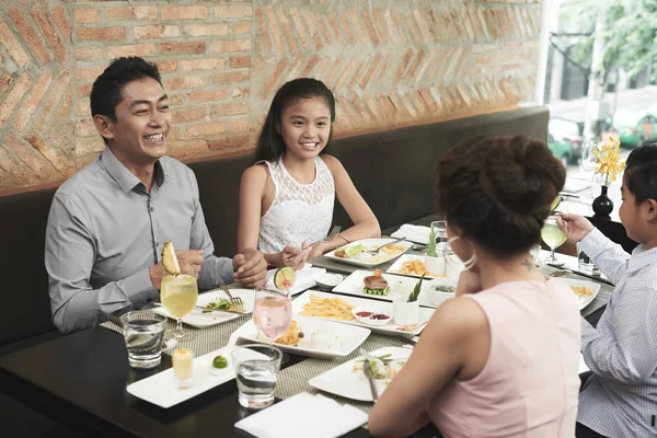 レストランで昼食中に4人の幸せな家族がお互いに話す — ストック写真