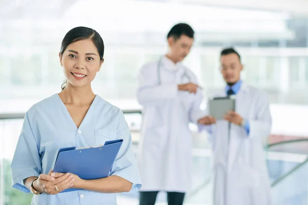 Porträt Der Hübschen Jungen Vietnamesischen Krankenschwester Ihre Sprechenden Kollegen Hintergrund — Stockfoto