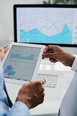 İş yöneticilerinin elinde tablet bilgisayarda mali diyagram ile belge