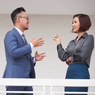 Genç kız işadamı ofis koridorunda ayakta iken genç işkadını bir şey açıklayan