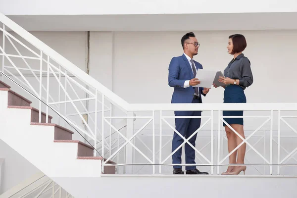 Dos Jóvenes Empresarios Sosteniendo Documento Tableta Hablando Entre Mientras Están — Foto de Stock