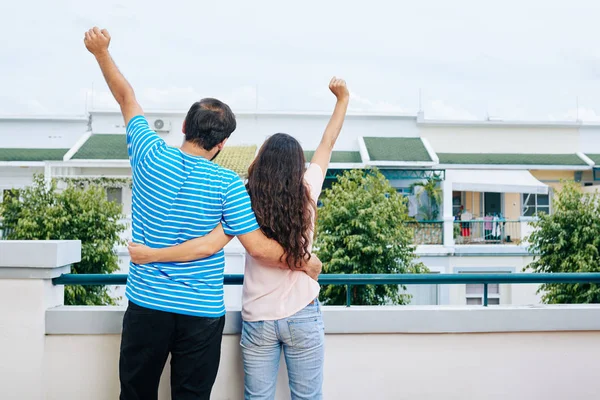 Szczęśliwy Przytulanie Para Podnoszenie Rąk Obchodzi Zakup Nowego Domu Widok — Zdjęcie stockowe