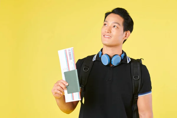 Glimlachend Dromerige Jonge Aziatische Man Met Paspoort Vliegticket Opzoeken — Stockfoto