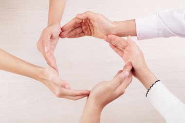 Bir grup insan elele bir araya getirerek beyaz arka plan üzerinde dostluk ve birliklerini sergiliyorlar.