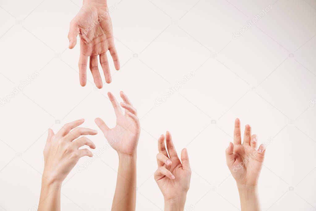 Close-up of young people stretching hands and supporting each other isolated on white background