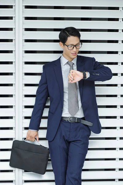 メガネと古典的なスーツで成功した若いアジアのビジネスマンは 彼の時計の時間をチェック — ストック写真