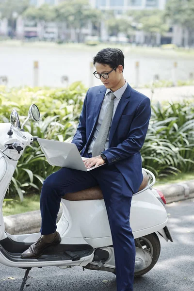 メガネと古典的なスーツのハンサムな若いアジアの起業家は 屋外に座って ラップトップで作業 — ストック写真