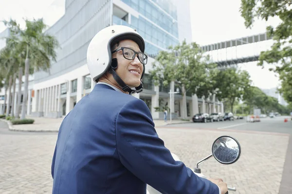 Sonriente Joven Empresario Asiático Mirando Alrededor Cuando Monta Scooter Ciudad —  Fotos de Stock