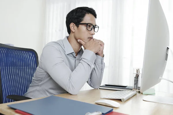 Pensive Unga Vietnamesiska Entreprenör Läsa Dokument Skärmen Datorn När Arbetar — Stockfoto