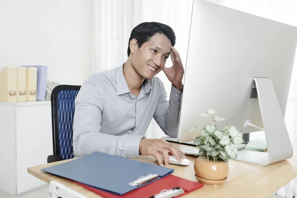 Lächelnder Junger Asiatischer Geschäftsmann Berührt Stirn Wenn Bericht Auf Bildschirm — Stockfoto