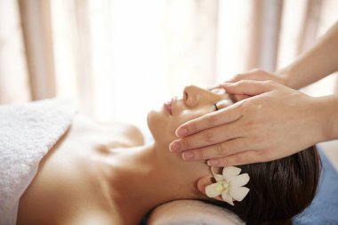 Genç güzel Vietnamlı kadın spa salonunda yağlar ile profesyonel rahatlatıcı yüz masajı alıyorum