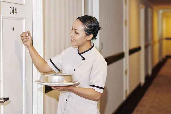 Asiática Joven Camarera Uniforme Blanco Celebración Cena Bandeja Llamando Puerta —  Fotos de Stock