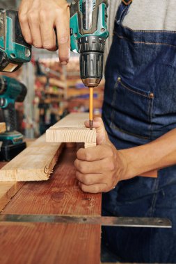 Ahşap plakaları delerken uzatılmış bit kullanarak marangozun yakın çekim görüntüsü