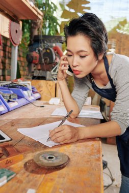 Ciddi genç kadın marangoz telefonla müşteri sipariş kabul