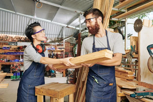 Lachende Vrouwelijke Timmerman Denim Schort Geven Stapel Houten Planken Aan — Stockfoto