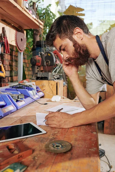 Ernstige Bebaarde Timmerman Praten Telefoon Met Klant Tekening Schets Van — Stockfoto