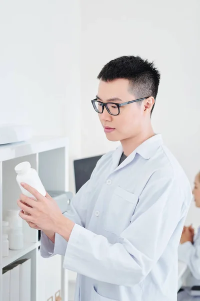 Νέοι Ασίας Φαρμακοποιός Λευκό Ποδιά Λαμβάνοντας Κοντέινερ Χαπιών Και Δισκίων — Φωτογραφία Αρχείου